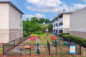 a fenced in play area in front of some apartments